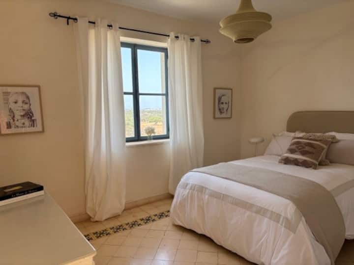 Chambre lumineuse et apaisante avec vue dégagée sur la nature. Décoration épurée, tons doux et literie confortable pour un séjour reposant dans une ambiance sereine et chaleureuse.