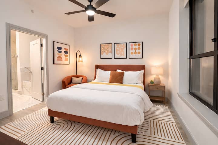 Dormitorio principal (master) con una cómoda cama queen, un diseño moderno y acogedor, y acceso directo a un baño privado en suite para mayor comodidad.