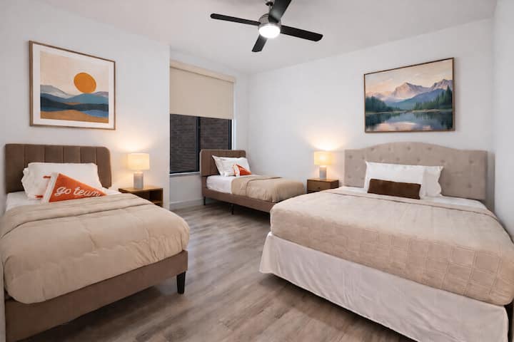 Habitación espaciosa y versátil con una distribución única que incluye 1 cama queen y 2 camas individuales, ideal para familias o grupos. Con conexión práctica a un baño compartido para huéspedes para un acceso fácil.