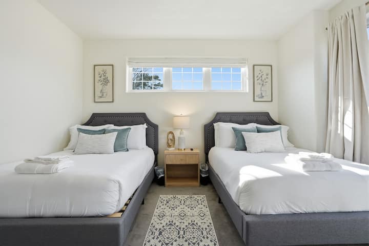 Bedroom 4 with two full beds, large windows, and a 75" Smart TV.