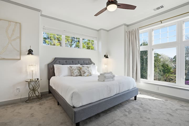 Upstairs king master suite with large windows, walk in closet, and 75" Smart TV.