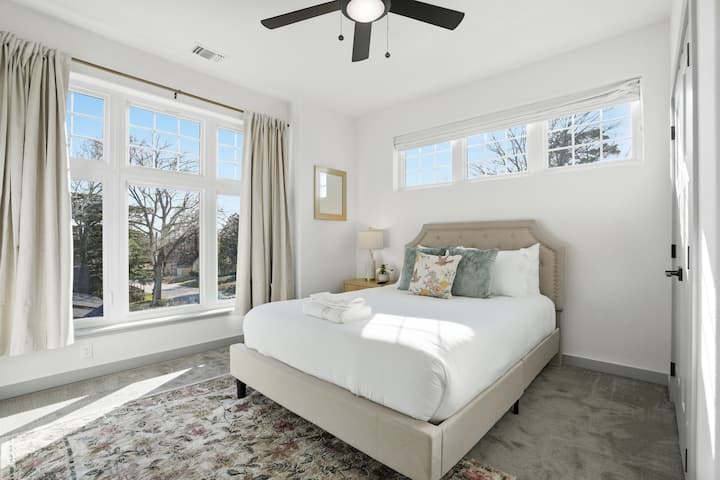 Bright Bedroom 3 with queen bed, large windows, and 75" Smart TV.