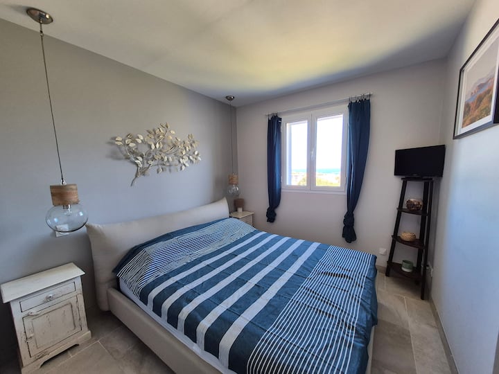 Chambre à coucher avec lumière naturelle et vue sur la mer