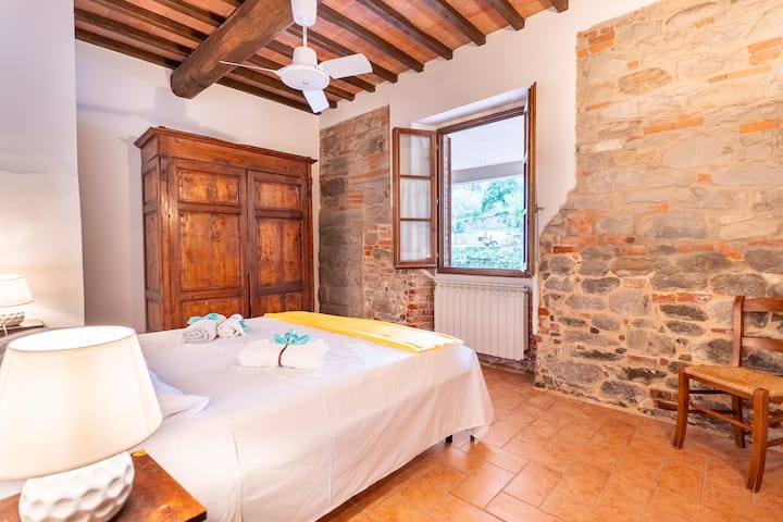 سحر ريفي مع جدران من الطوب المكشوف وخزانة ملابس كبيرة.