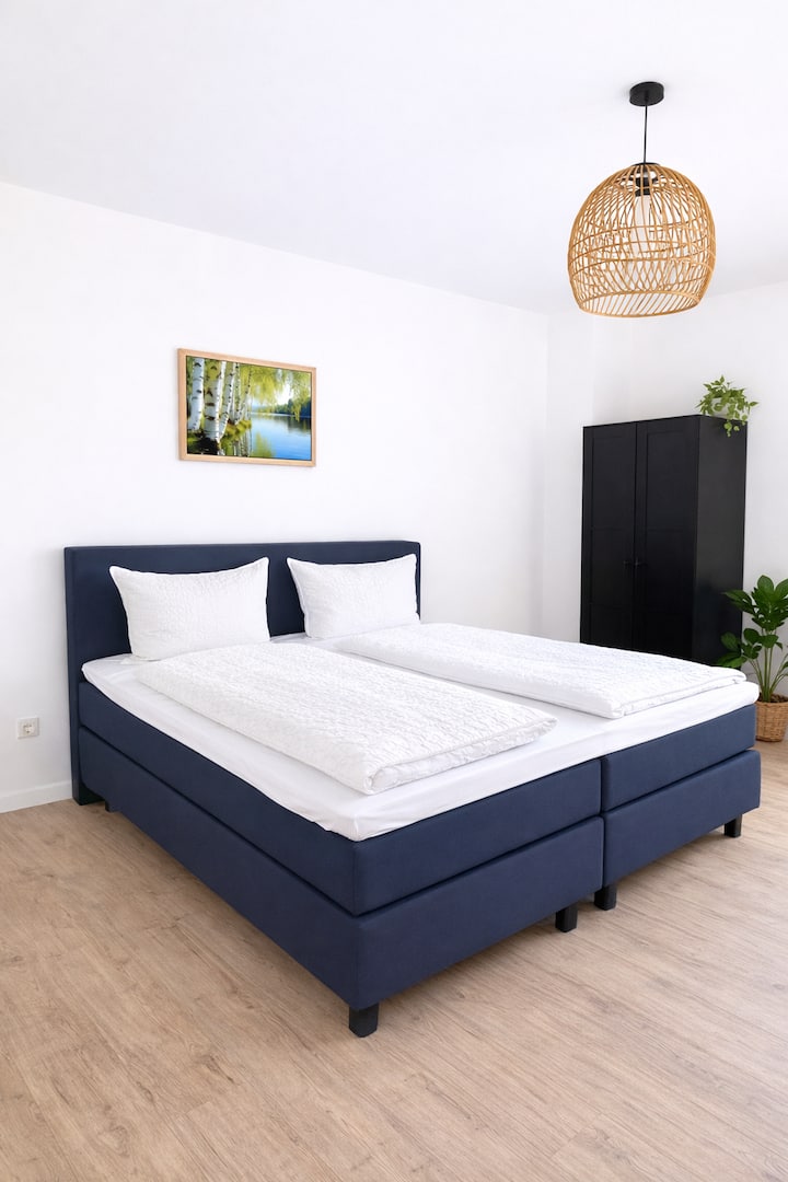 Dhomë gjumi e madhe me një krevat të rehatshëm me bazament me susta "king-size" 1,80 x 2,00 m dhe një atmosferë qetësuese. Detajet elegante dhe hapësira e bollshme të sigurojnë një qëndrim relaksues dhe net të qeta në zemër të Rüdesheim.