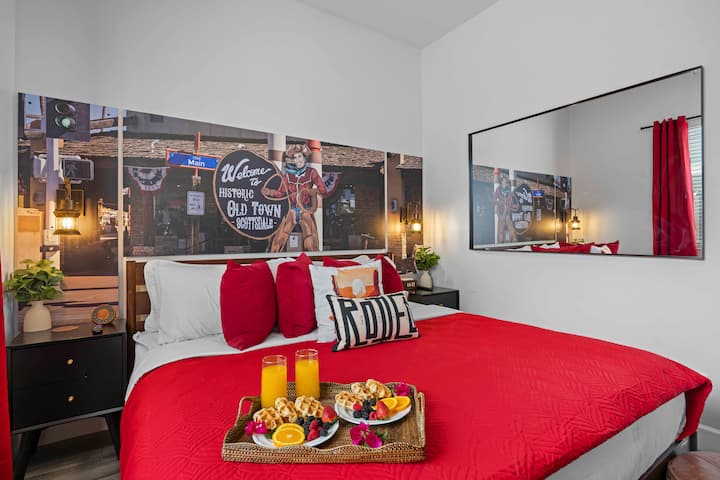 Cozy bedroom with bold red accents, plush bedding, and stylish wall art, creating a vibrant and inviting space to unwind.
