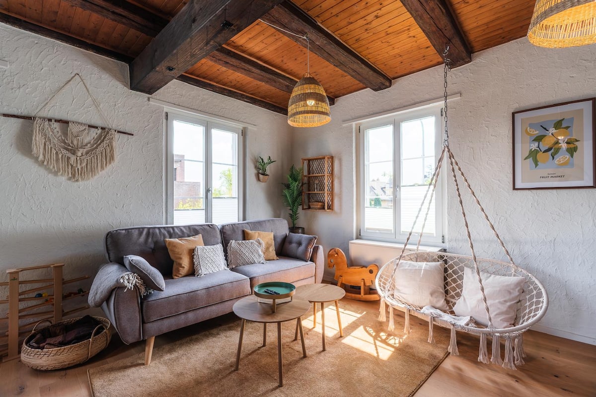 Heller Wohnbereich mit Holzbalken und Hängesessel