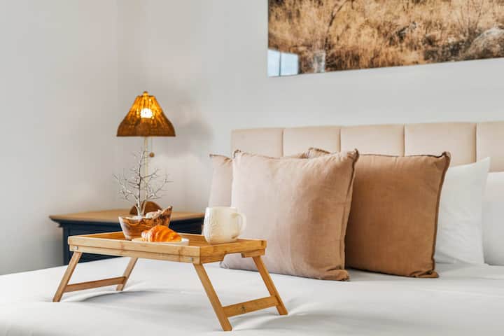 Acogedor rincón de dormitorio en esta villa de Aruba, con texturas suaves e iluminación cálida, perfecto para mañanas tranquilas y relajadas.