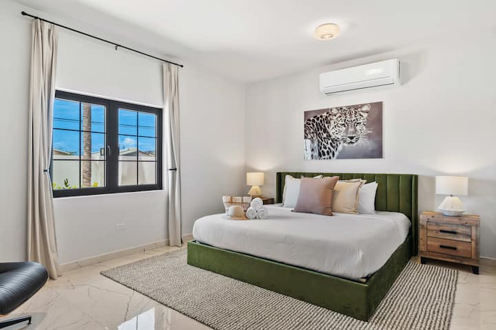 Dormitorio principal en esta villa de Aruba con sábanas suaves y aire acondicionado, diseñado para disfrutar de noches de descanso después de los días de playa