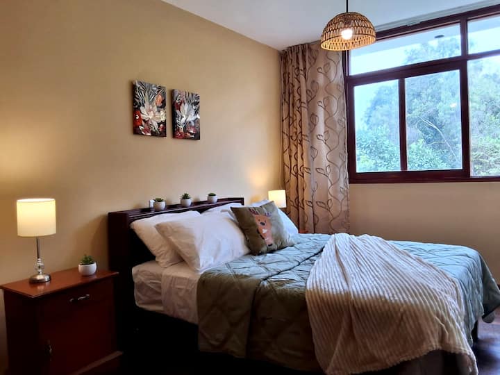 Vista lateral del cuarto. La habitación tiene cortinas, pero no son opacas y dejan pasar la luz.