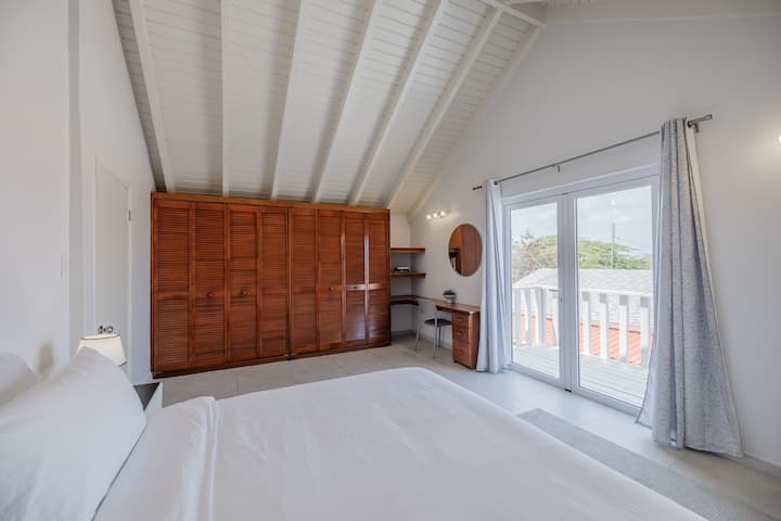 ऊँची छत और बालकनी की सुविधा वाला बड़ा-सा मास्टर बेडरूम।