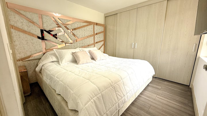 Quarto principal com TV e armário para guardar roupas.