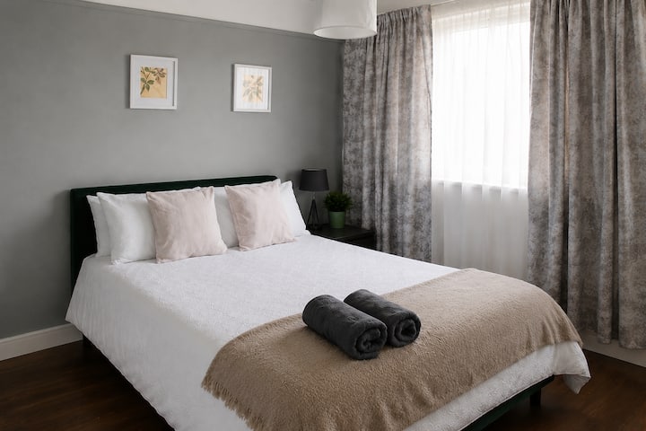Chambre lumineuse et confortable avec des draps doux et un décor moderne apaisant