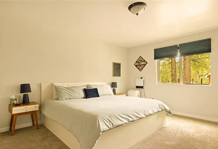 King bed, room has a workstation and a private entrance to a small deck at the front of the house. Also has a smart TV. 