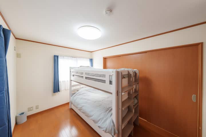 Debajo de la litera hay una cama extraíble guardada.La ropa de cama se guarda en el armario.