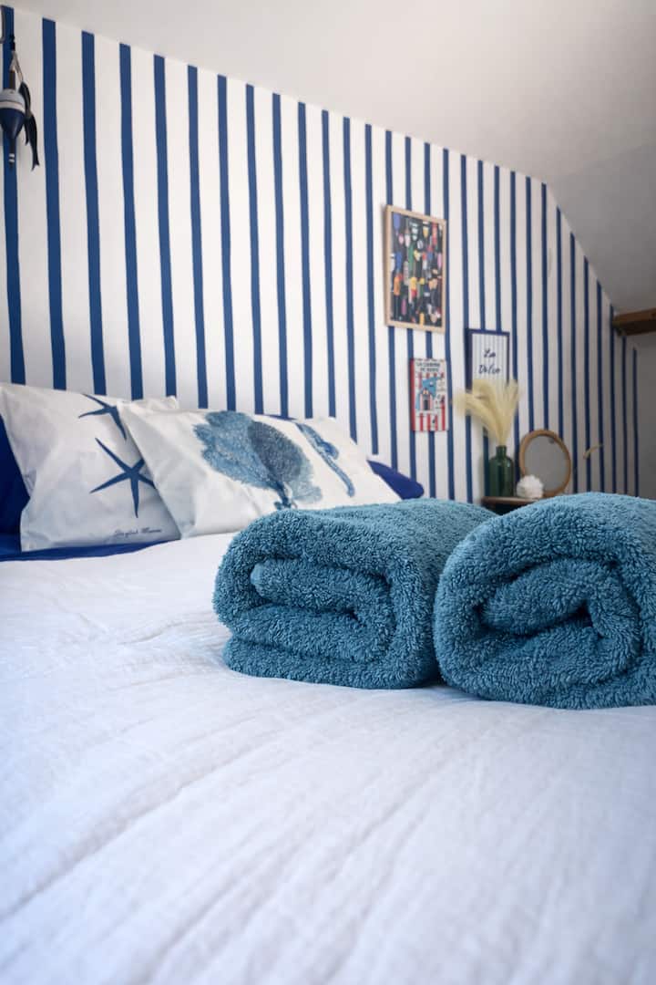 A bedroom with a seaside vibe, cozy and relaxing, perfect for extending your getaway. Its striped design and decorative details give it real character.