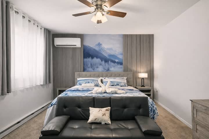 Apartmán Snowcap Mountain Suite ❄️ ponúka luxusnú manželskú posteľ s prémiovou posteľnou bielizňou, vlastný obývací kút s futónom, smart TV, Wi-Fi pripojenie a toaletný stolík. Svetlé okná, zatemňovacie závesy a mini klimatizácia/kúrenie zaisťujú pokojný a pohodlný pobyt.
