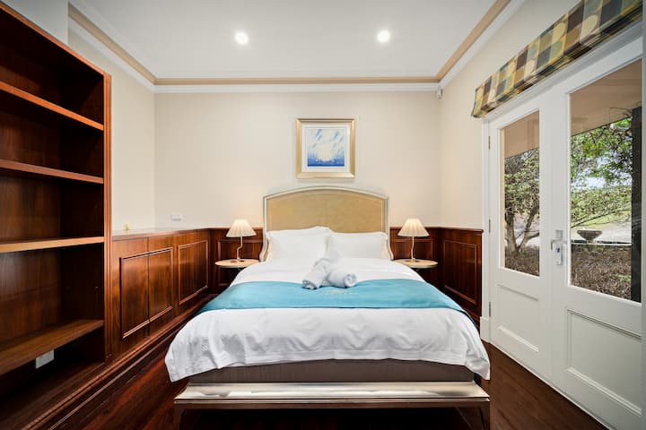 Cozy, elegant bedroom with outdoor access and warm wood accents