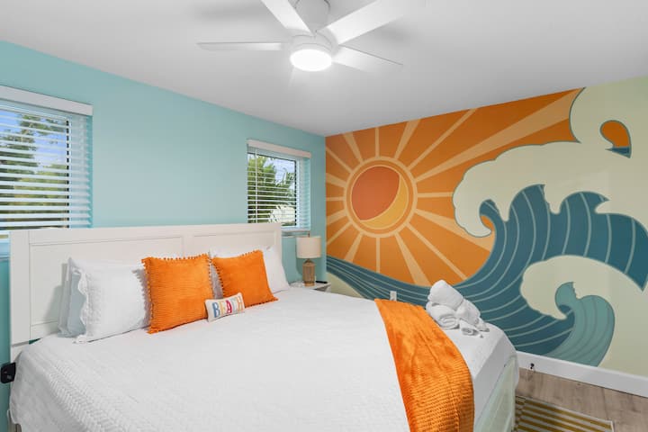 Habitación costera luminosa con una cómoda cama king y un atrevido mural inspirado en el mar. Con colores frescos, luz natural y una decoración de estilo playero, es un espacio relajante para descansar después de un día bajo el sol.