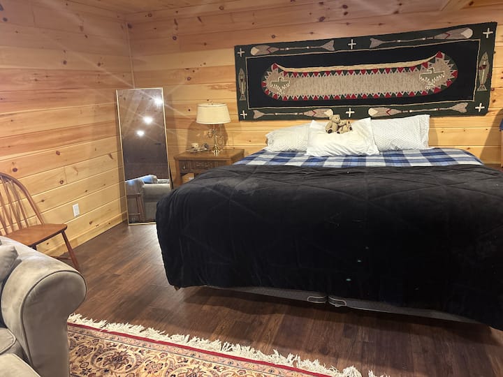 Ce grand lit deux places se trouve dans l'« espace commun » du sous-sol – salle de bain complète adjacente