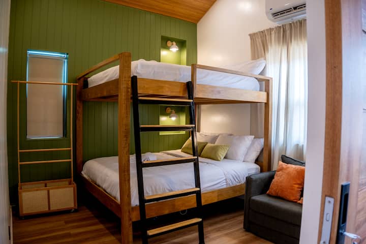 A wider look at the bunk room, with that green accent wall carrying the theme through.
