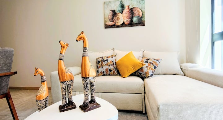 Moderna sala en Polanco con excelente iluminación natural, ideal para relajarte o trabajar cómodamente. Cuenta con sofá amplio, Smart TV y WiFi rápido, perfecta para estancias de negocio o descanso.