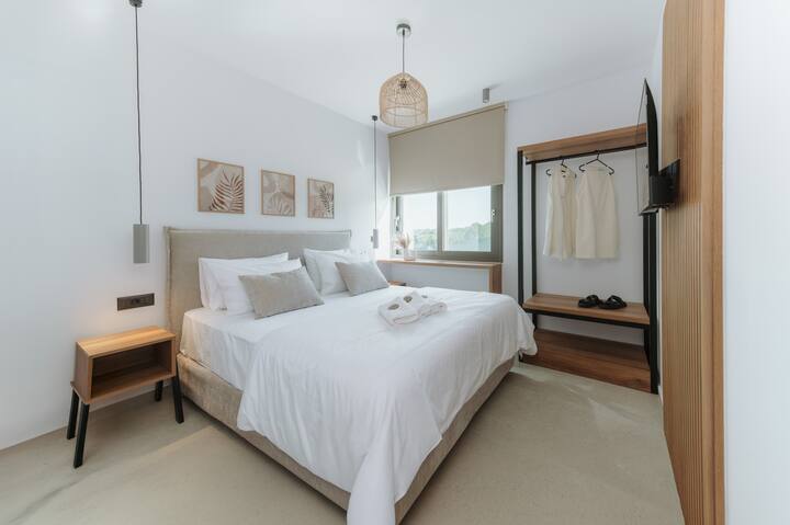 Cómodo dormitorio con una cama matrimonial, un diseño sobrio y grandes ventanales que dejan entrar la luz natural.