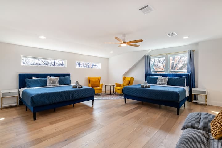Cette grande chambre à coucher est dotée de deux lits bleus douillets et d'un coin salon jaune confortable, ce qui en fait un espace idéal pour les familles ou les groupes.