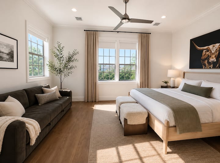 Spacious king bedroom with queen pull-out futon, attached bathroom, TV, and cozy seating area.