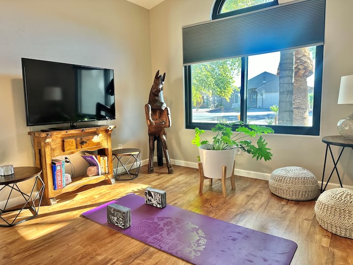 Sala de estar adicional con sofá cama, colchoneta de yoga y TV inteligente.
