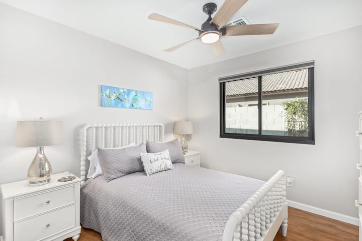 El segundo dormitorio tiene una cómoda cama tamaño queen, un tocador y mesitas de noche.