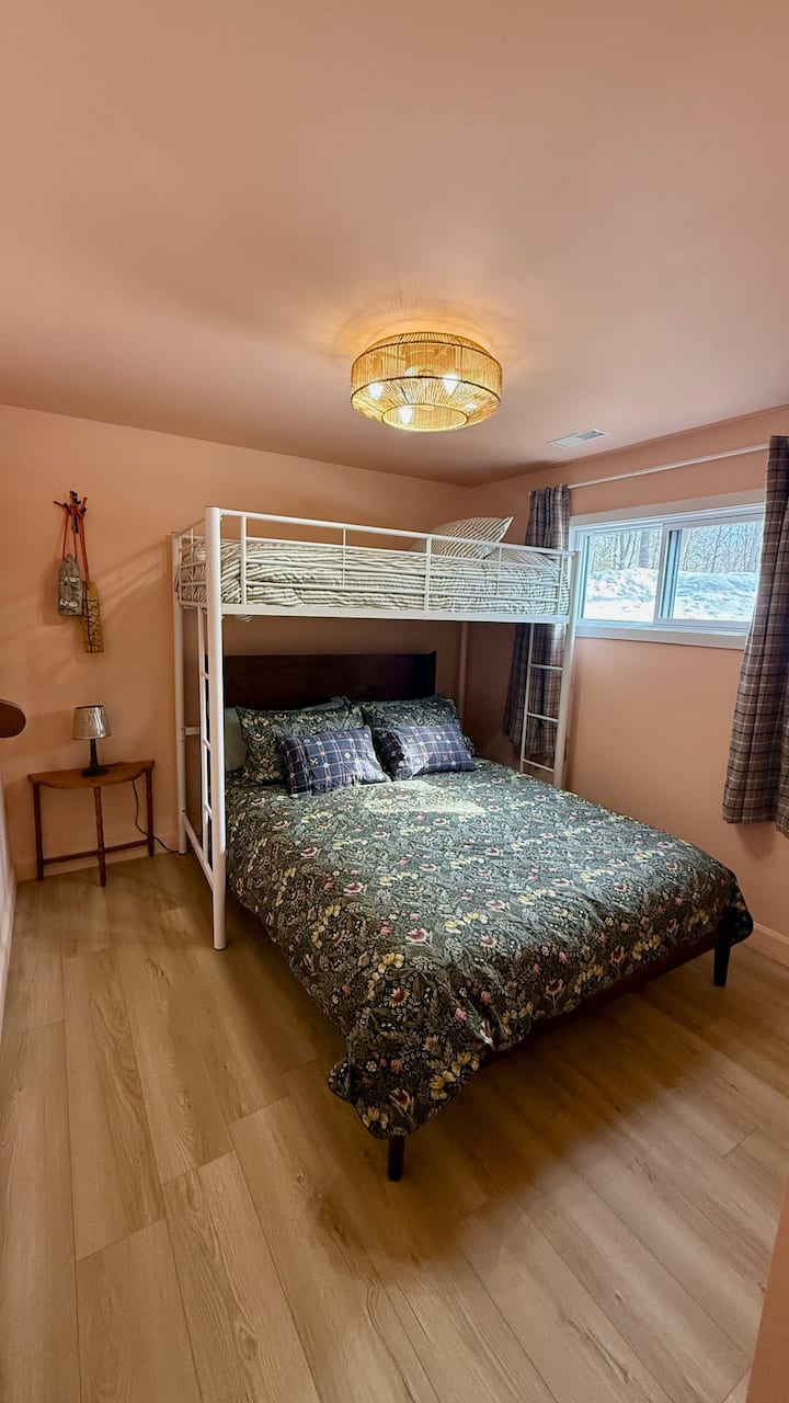 Walkout basement bedroom with queen bed and a separate double loft