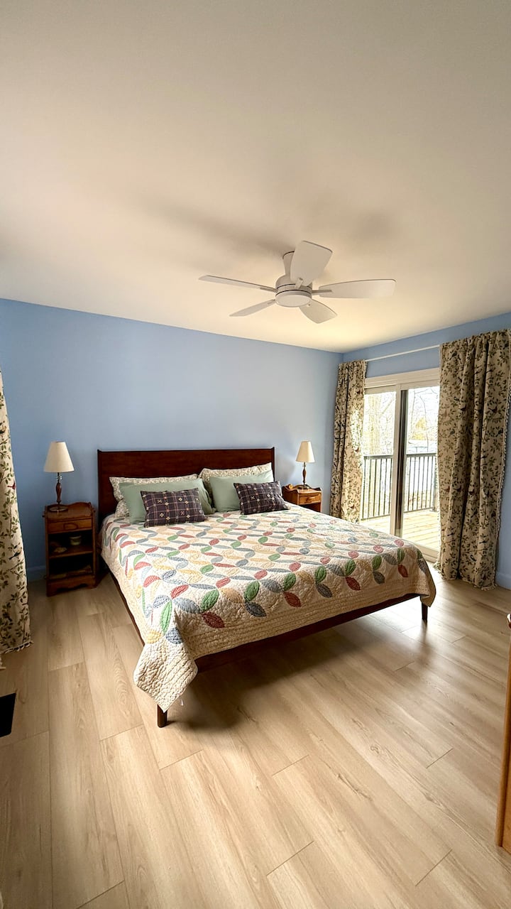 Main level King Bedroom with a sliding door walkout and lake views.