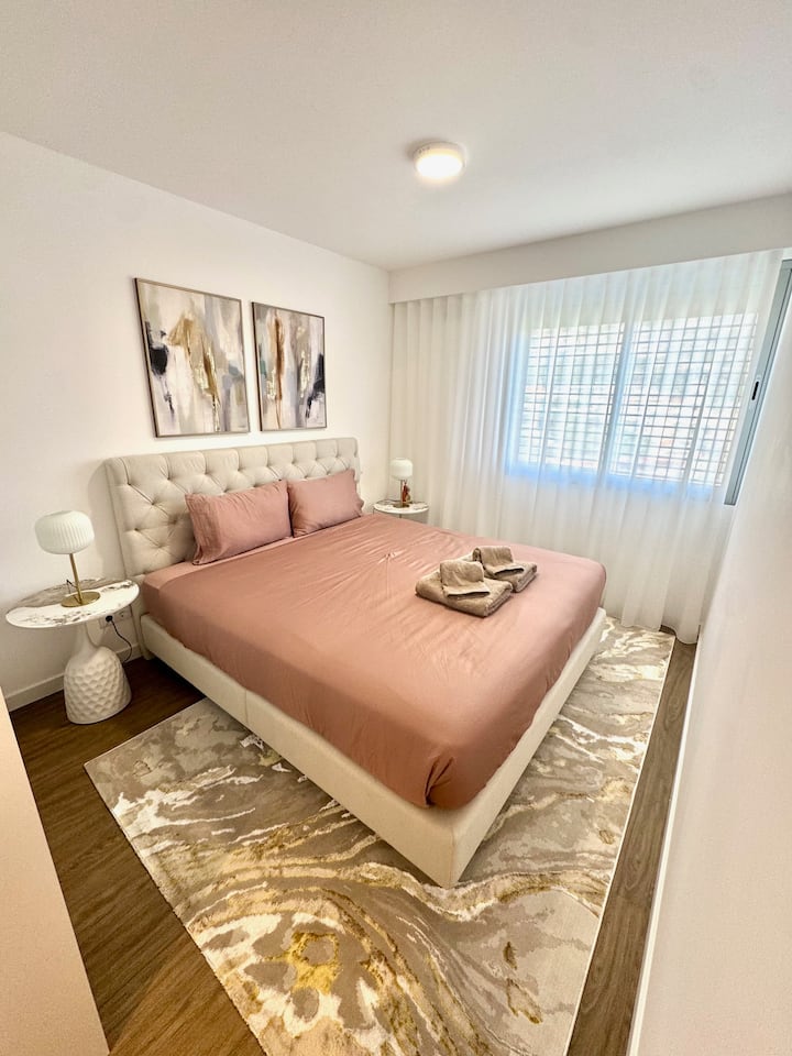 Master bedroom with private bathroom, spacious wardrobe, and a comfortable bed with quality linens. Blackout blinds, heating, and air conditioning. Wake up to beautiful mountain views.
