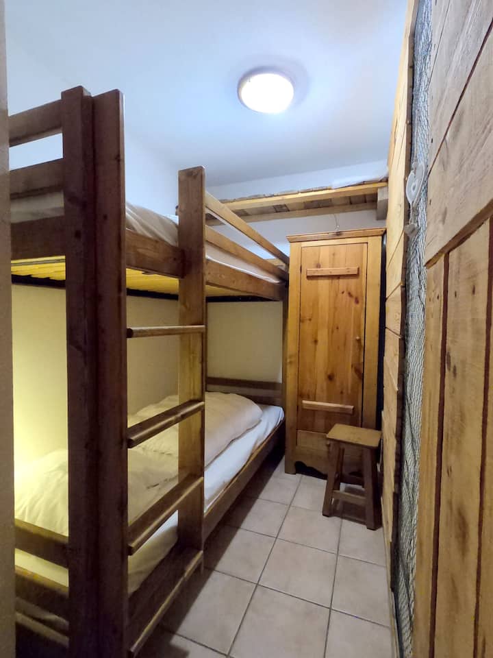 Chambre cabine dans l'entrée, séparée du séjour par un rideau