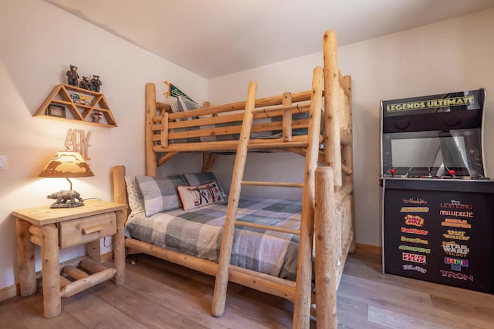 Bedroom 3 features a log bunk bed and a Legends Ultimate arcade cabinet loaded with classic games — a great setup for kids or anyone who wants their own little corner of fun at the cabin.