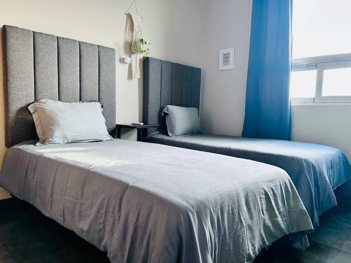 Спалня с 2 единични легла, телевизор и пълен гардероб. С красив директен изглед към града, Серо де ла Сила, парк Фондидора и Пасео Санта Лусия.