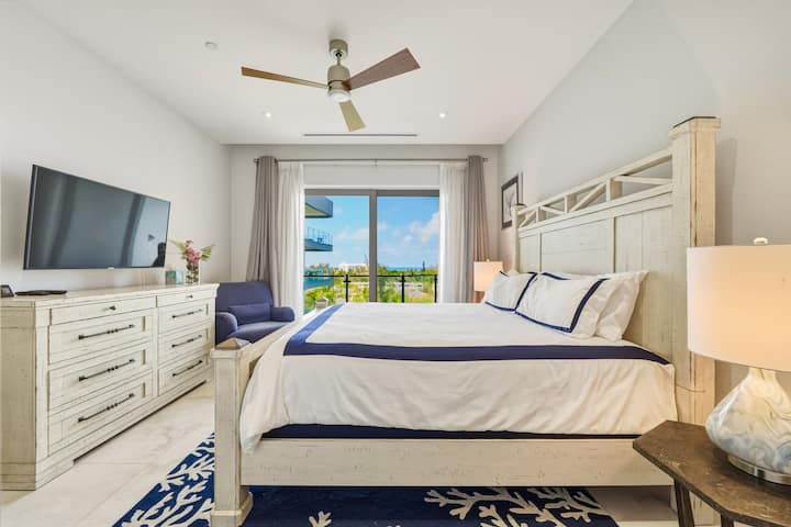 Primary bedroom with a plush king bed, ocean views, and a smart TV for relaxing after beach days.