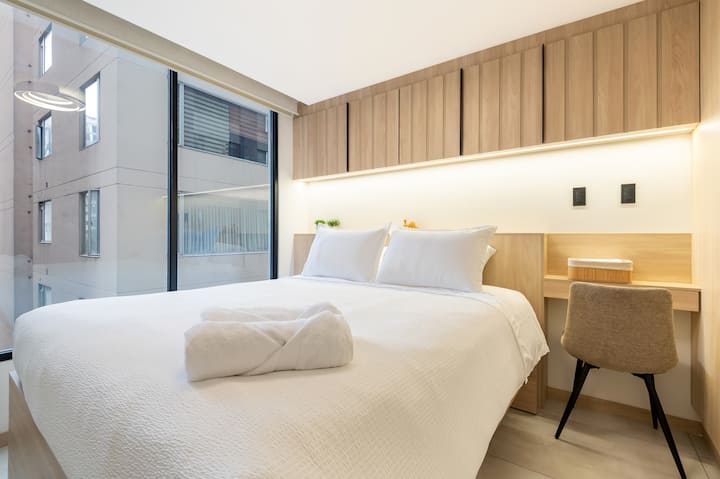 Nuestro amplio y acogedor studio tiene cama Queen de 2.5 plazas, cortinas traslúcidas y black out, un TV smart de 55" y si vienes en familia, la cama principal aloja una cama nido, muy confortable con colchón de 1 plaza y ropa de cama.