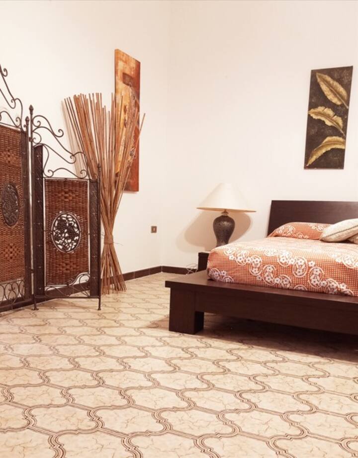 Amplia y luminosa, esta habitación combina la comodidad con el estilo mediterráneo. Equipada con una acogedora cama queen, armarios de madera y acceso directo al balcón privado. Perfecto para quienes buscan relajarse en un entorno bien cuidado con mucha luz natural.