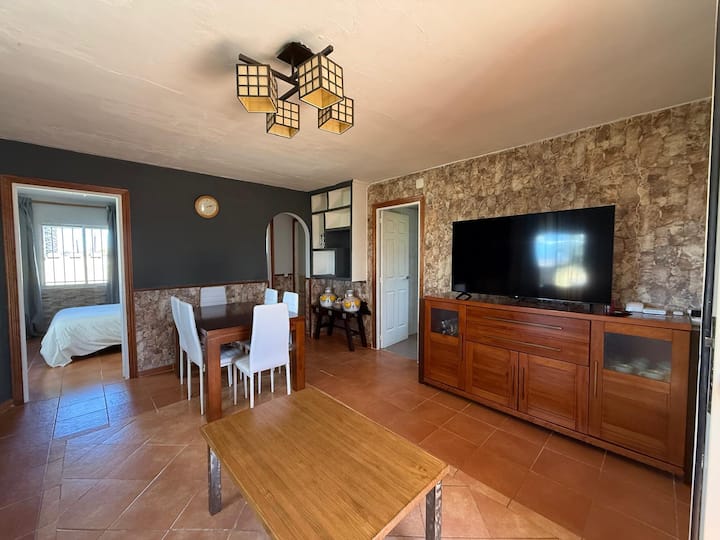 Salón-comedor con TV y acceso a los dormitorios.