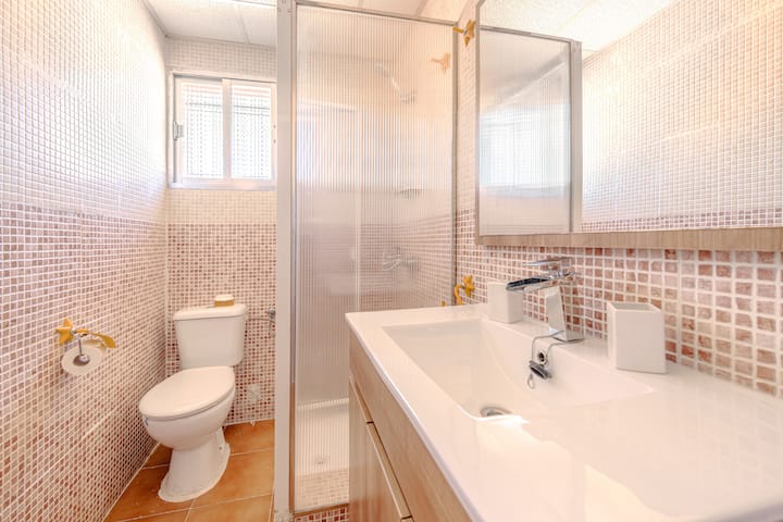 Segundo baño con ducha y azulejo de gresite.