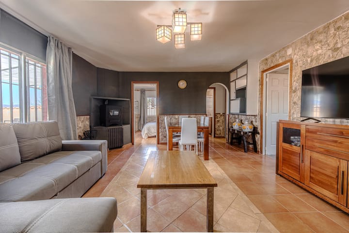 Salón con mesa de madera y TV: reuniones y cenas con espacio de sobra.