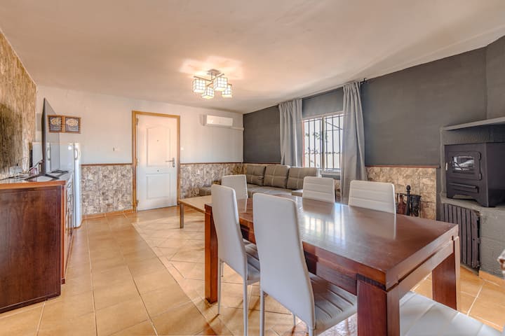 Comedor amplio con aire acondicionado y mesa de madera.