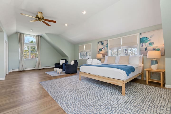 Recámara en el segundo piso (unidad 2) con cama king y zona de estar.
