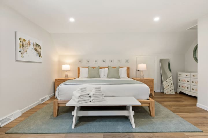 Recámara en el segundo piso (unidad 1) con cama king, espacio de trabajo dedicado y luz natural.