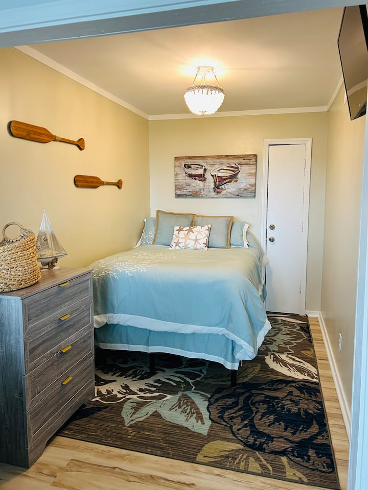 Tucked away like a cozy seaside retreat, this inviting bedroom offers a peaceful place to unwind after a day of exploring. The plush full-size bed is dressed in soft linens, creating a calming atmosphere that instantly puts you at ease.