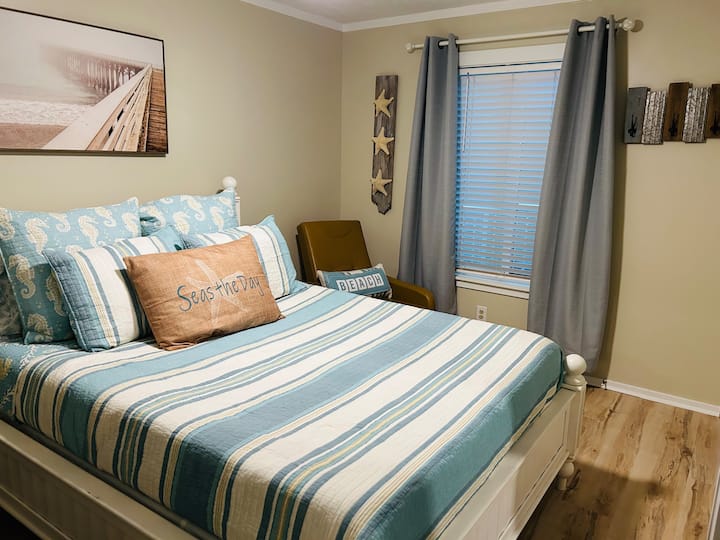 The spacious master bedroom features a plush queen-size memory foam mattress for ultimate comfort, complemented by a generous closet, stylish dresser, cozy lounge chair, and a television—creating a perfect retreat for relaxation.