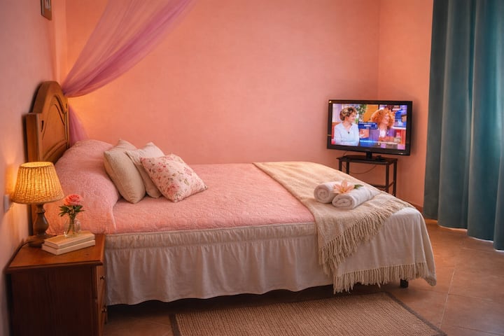Habitación principal con una cama cómoda, televisión y acceso directo a una agradable terraza.