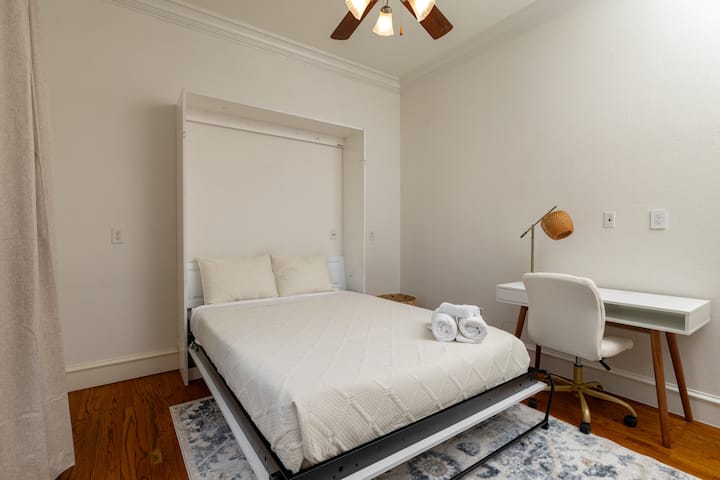 Versatile downstairs bedroom with a queen Murphy bed and workspace.